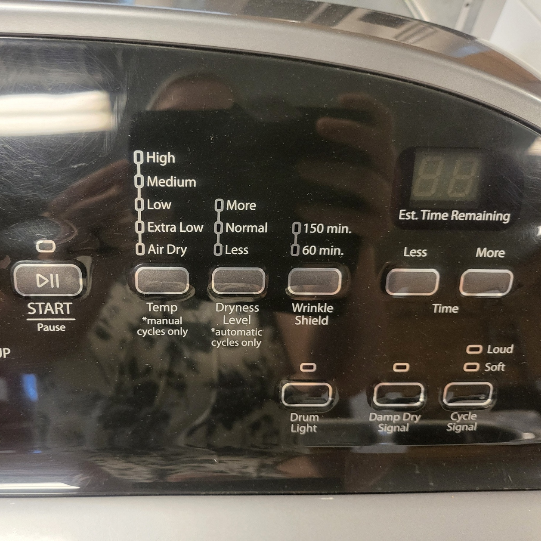 Control panel of a dryer with various settings and indicators.