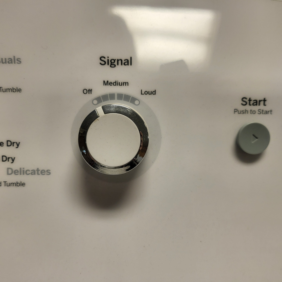 Control panel of a dryer with signal, medium, and start buttons.