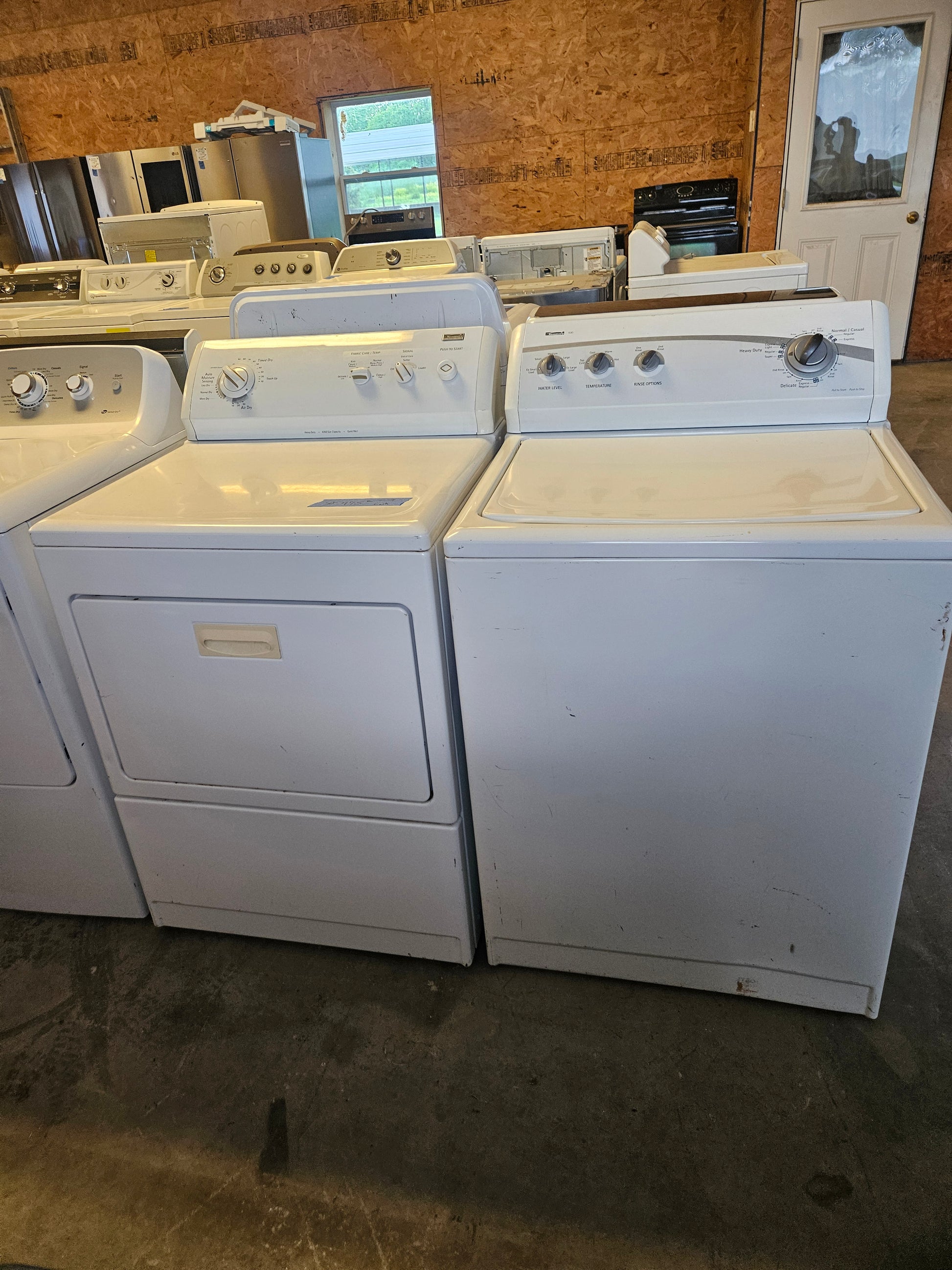 A set of white Kenmore elite direct drive washer and dryer appliances, displayed with the washer on the left and the dryer on the right.